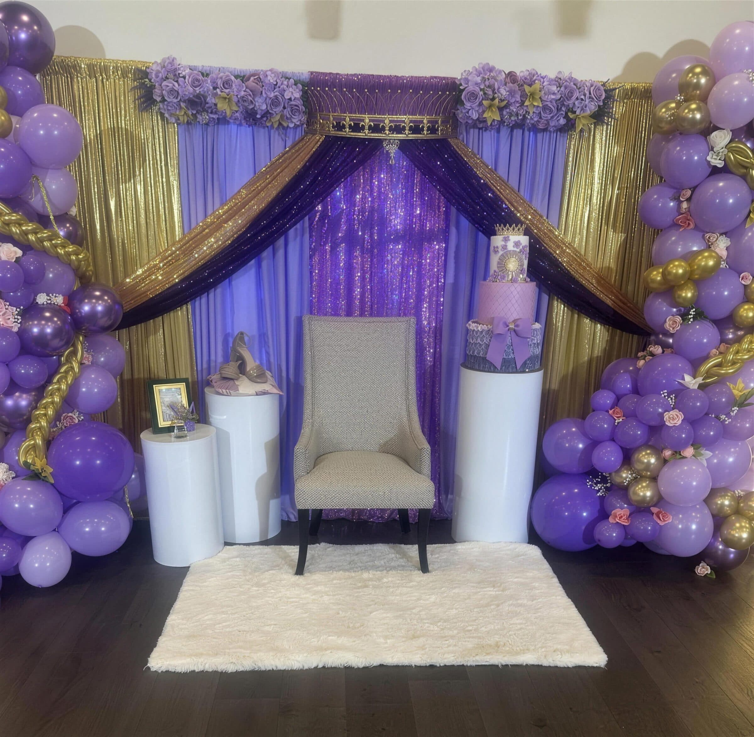 Wider view of the purple and gold quinceanera stage - sequin drape, throne chair, cake pedestal and floral balloon columns at The Cove at St. Johns, St. Johns County FL