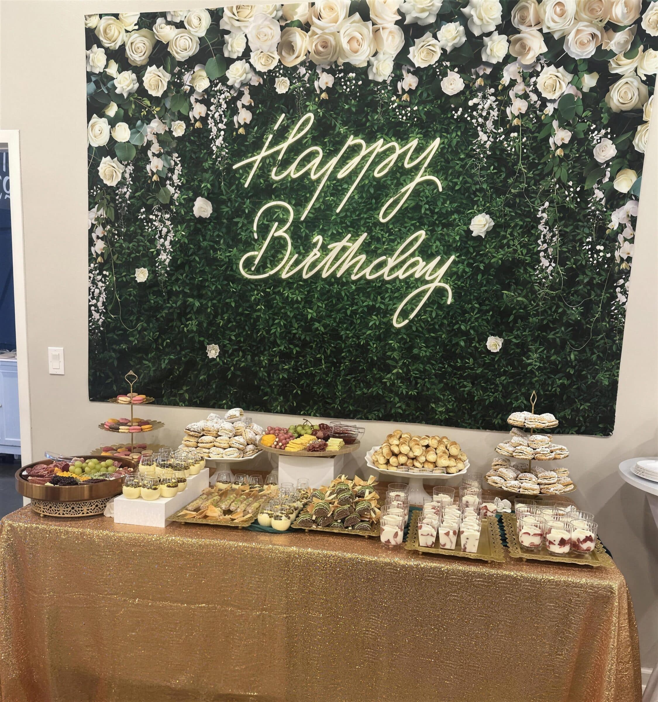 Gold sequin dessert table of macarons, cream puffs and parfaits under a Happy Birthday neon sign on a white-rose greenery wall at The Cove at St. Johns, St. Johns County FL