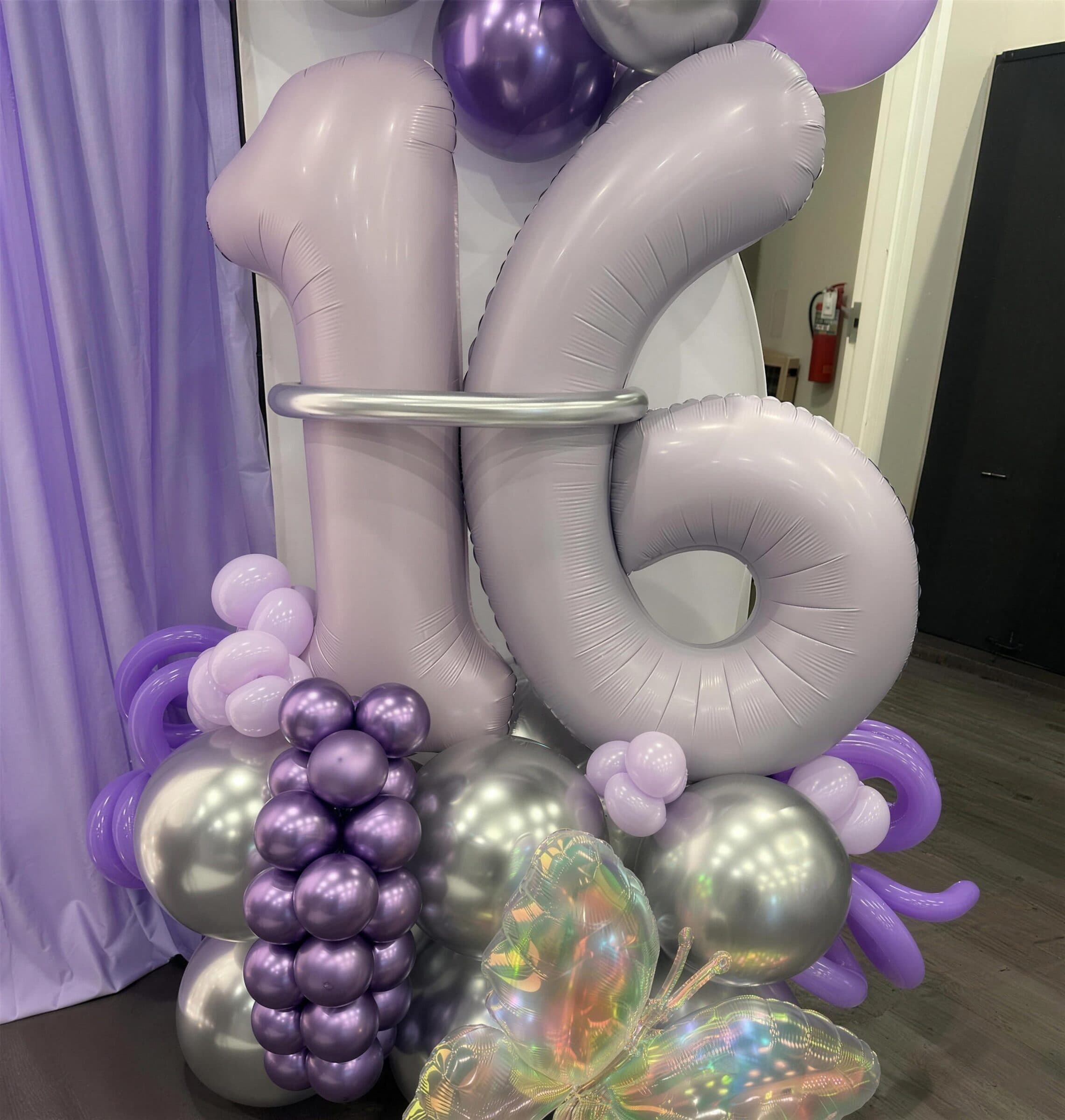 Lilac 16 number balloons stacked with purple and silver chrome spheres and an iridescent butterfly at a Sweet 16 at The Cove at St. Johns, Fruit Cove, St. Johns County FL